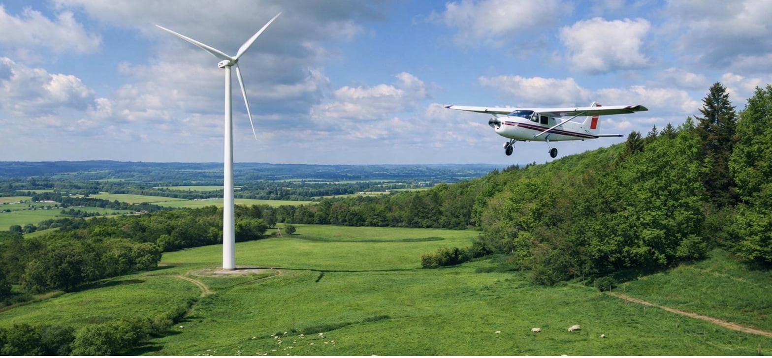 Avion survolant une éolienne en campagne limousine
